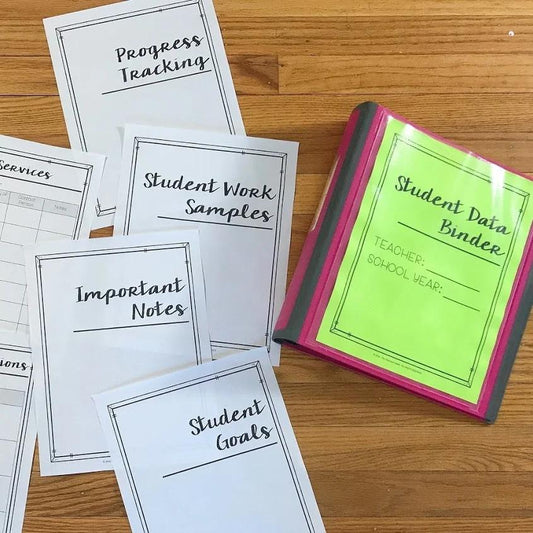 Collection of educational binders and sheets on a wooden surface.